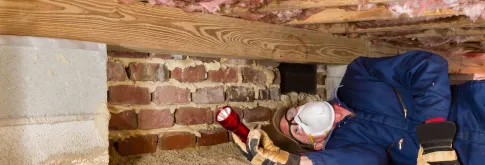 Person inspecting under crawl space